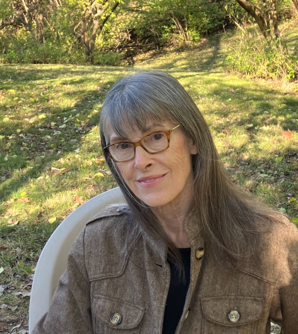 Mary Helen Stefaniak sits on her screened porch with a copy of her third novel, The World of Pondside, newly released by Blackstone Publishing in April 2022. Her book of short essays, The Six-Minute Memoir, will be released in fall 2022.